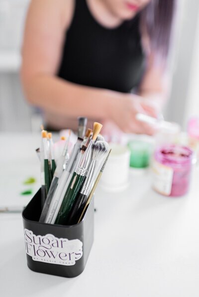 woman painting sugar flower