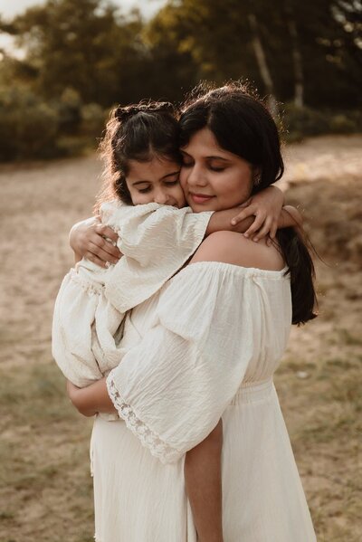 Mama en dochter tijdens zwangerschapsshoot in de duinen