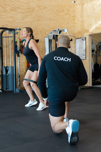 A Skopos Athletics coach in Dundas, MN, guiding a gym member through a personalized strength training session.
