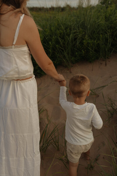 mom and son holding hands in prince edward island for family photos