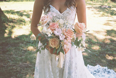 A bridal bouquet  held by a faceless bride, representing an example of film wedding photography taken by Among the Oaks.