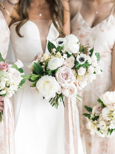 White and blush wedding bouquet featuring anemones and ranunculus.