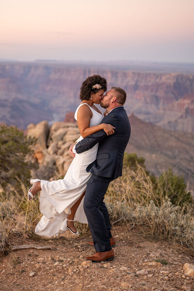 ouple kissing passionately after their Grand Canyon elopement, with the canyon’s dramatic cliffs and landscape surrounding them