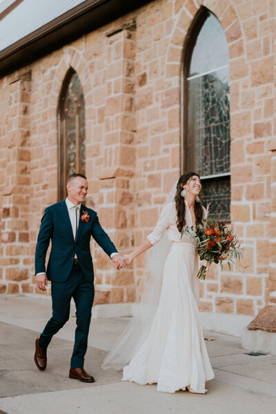 Bride and Groom walk down the aisle with a dusty blue, sage, and white bouquet at the St. Julien Hotel in Boulder, Colorado.