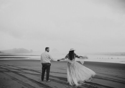 black and white image of bride and groom on beach