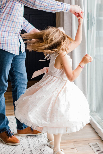 dad twirling daughter in dress