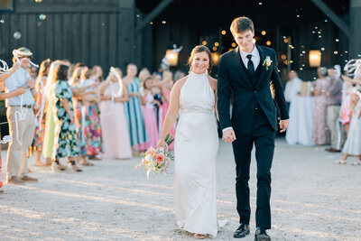 bride and groom exiting wedding reception as guests hold up sparklers