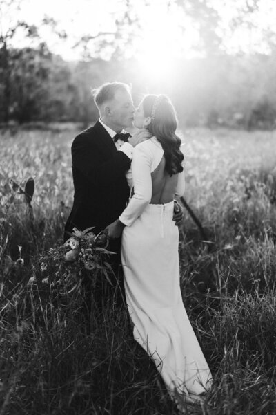 Groom picking up bride and enjoying an embrace at Albert River Wines - Mt Tamborine wedding