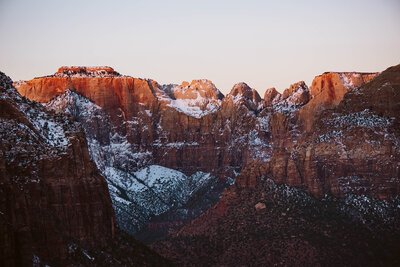 Zion national park rocks covered in a fresh dusting of white snow at sunrise.