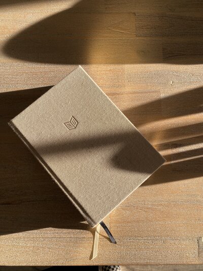 Bible laying on a table with shadows over it