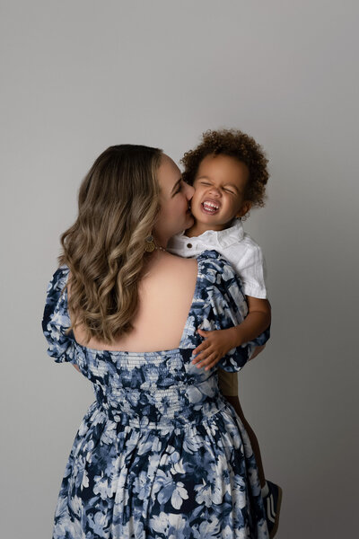 Austin family photographer capturing loving mother and toddler moment in floral dress studio session