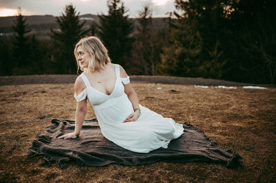 pregnant woman in a white dress posing for photos