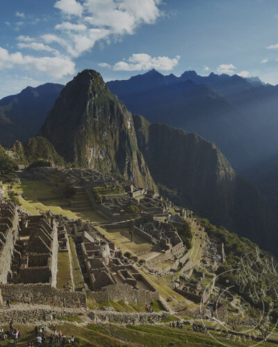 Machu Picchu at sunrise in Peru, with golden light illuminating the ancient Incan ruins, creating a breathtaking scene high in the Andes Mountains.