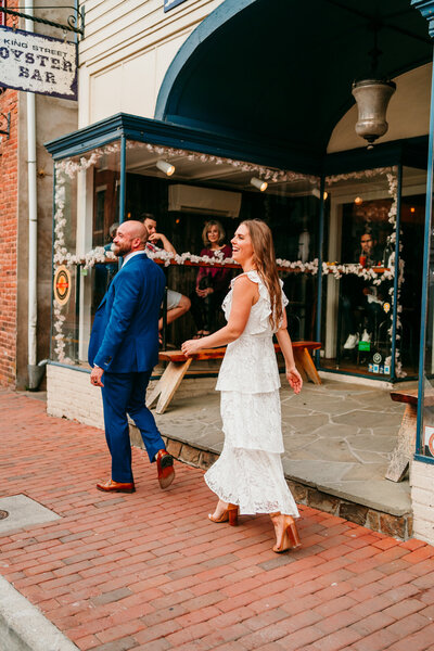 Couple walking hand-in-hand through historic downtown Virginia before their elopement