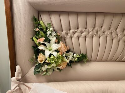 L shaped funeral arrangement that is on the inside of the casket lid
