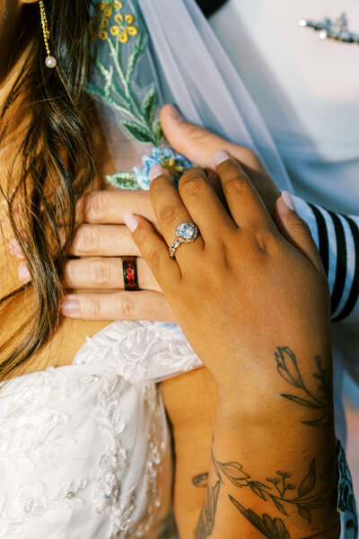 Close-up of a couple’s hands during their elopement, showcasing a diamond engagement ring and matching wedding bands, captured by Joseph Mayden in natural light.