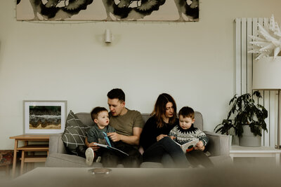 family sitting on couch and holding newborn