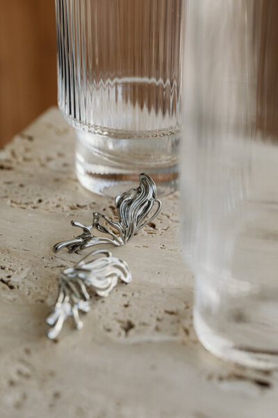 detail stříbrného šperku na mramorovém stole
