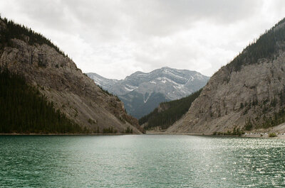 a glacier-blue lake with mountains rising behind it in Canmore, Albtera
