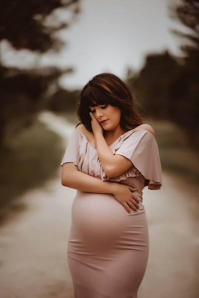 Pregnant woman in satin pink dress for maternity photo in Tampa Florida.