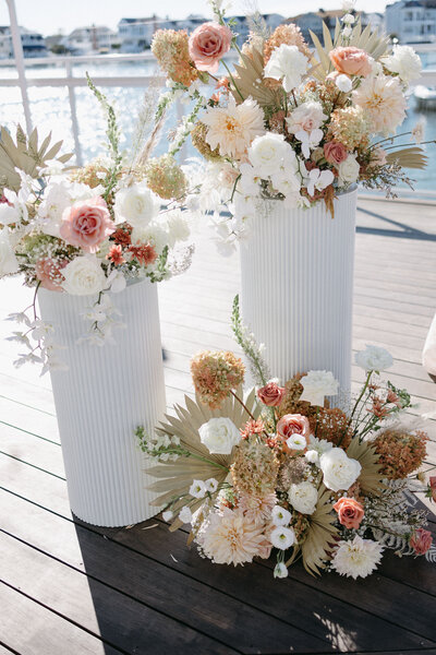 Intimate wedding ceremony backdrop with lush, colorful floral creations by Leigh Florist, enhancing the aisle and altar with seasonal blooms and greenery.