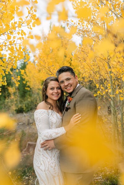 Classic portrait of bride and groom with colorado fall foliage in the foreground at their windy point campground wedding