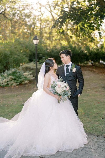 Bride and groom looking at each other in sunlit garden after ceremony in Toronto, fine art wedding photography