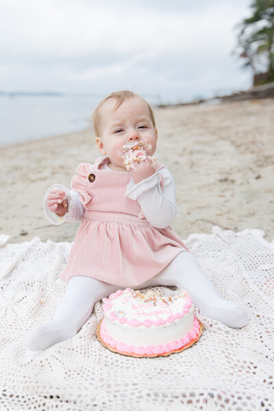 Baby eats cake during cake smash photo session in Buford