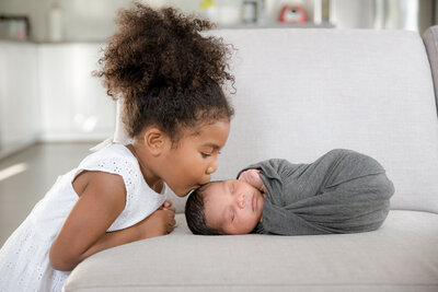 girl kissing newborn brother