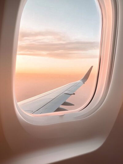 Airplane view through window of wing and a dreamy sunset
