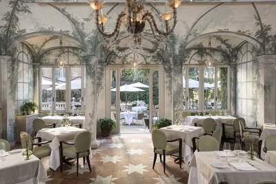 fancy dining hall with painted greenery, floor star tiles and crystal chandelier