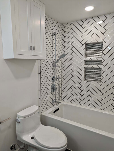 Shower remodel with white tile, new fixtures, and modern aesthetic
