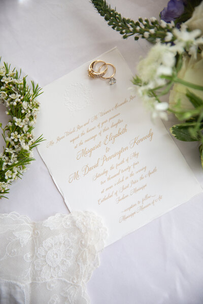 Wedding invitations featuring blind embossed monogram and gold engraving.