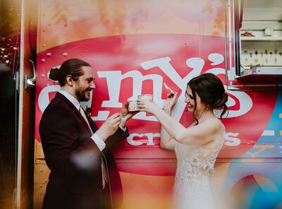 couple cheers with ice cream in front of amys truck