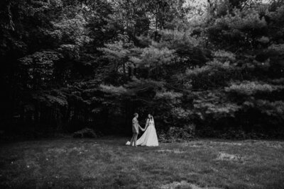 black and white image bride and groom holding hands