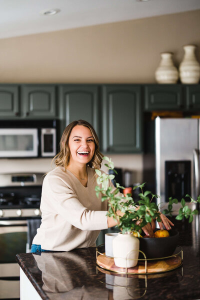 woman smiling and decorating her kitchen