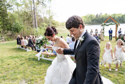 bride and groom smile at wedding ceremony at Carver Lake at Prospect Hill, NC