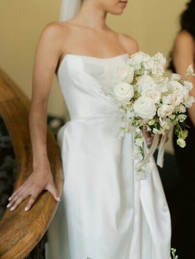 Bride holding stair rod and flowers taken by one of the top baltimore photographers
