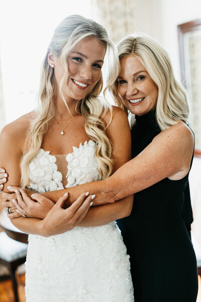 Bride and mother share a joyful moment before the wedding, celebrating with custom stationery by Seventh and Anderson.