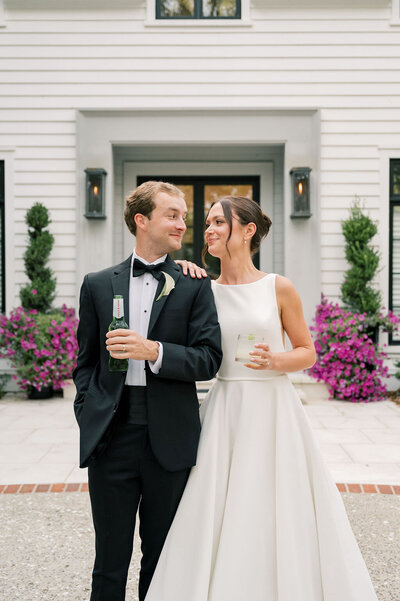 photo of bride and groom looking at each other while holding their champagne flutes outside their venue taken by Sea Island Wedding Photographer, Rhonda Rowell