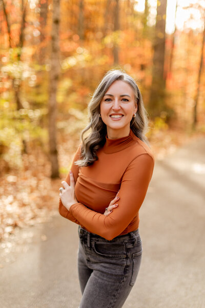 photographers in gatlinburg tn poses on a trail in the Smoky Mountains with her arms crossed and smiling for a headshot