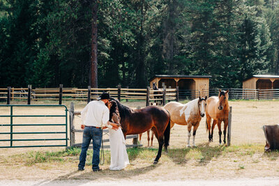 Bride and groom kissing by horses at The Ranch at Wolf Creek in St. Regis, MT
