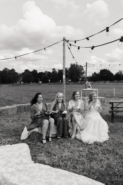 bruid met vriendinnen op een strobaal met taart