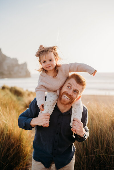 Toddler Daughter on Fathers Shoulders during a sunset photo session in Morro Bay.