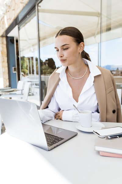A busy businesswoman on her laptop in an office.