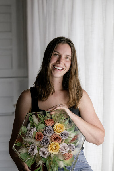 Bouquet preservation artist holding air dried flowers preserved in resin hexagon block