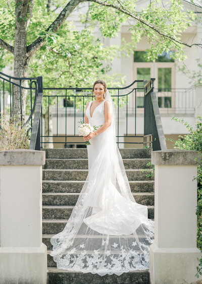 Woman standing in wedding dress on stairs for bridal portrait session