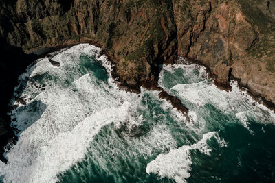 Aerial image of cliffs overlooking ocean during engagement photoshoot in New Zealand, photographed by Zanthe Vorsatz.