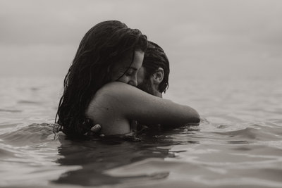 man and woman hugging in ocean
