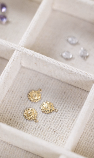 Gold sunflower charms and silver gemstone connectors for permanent jewelry.
